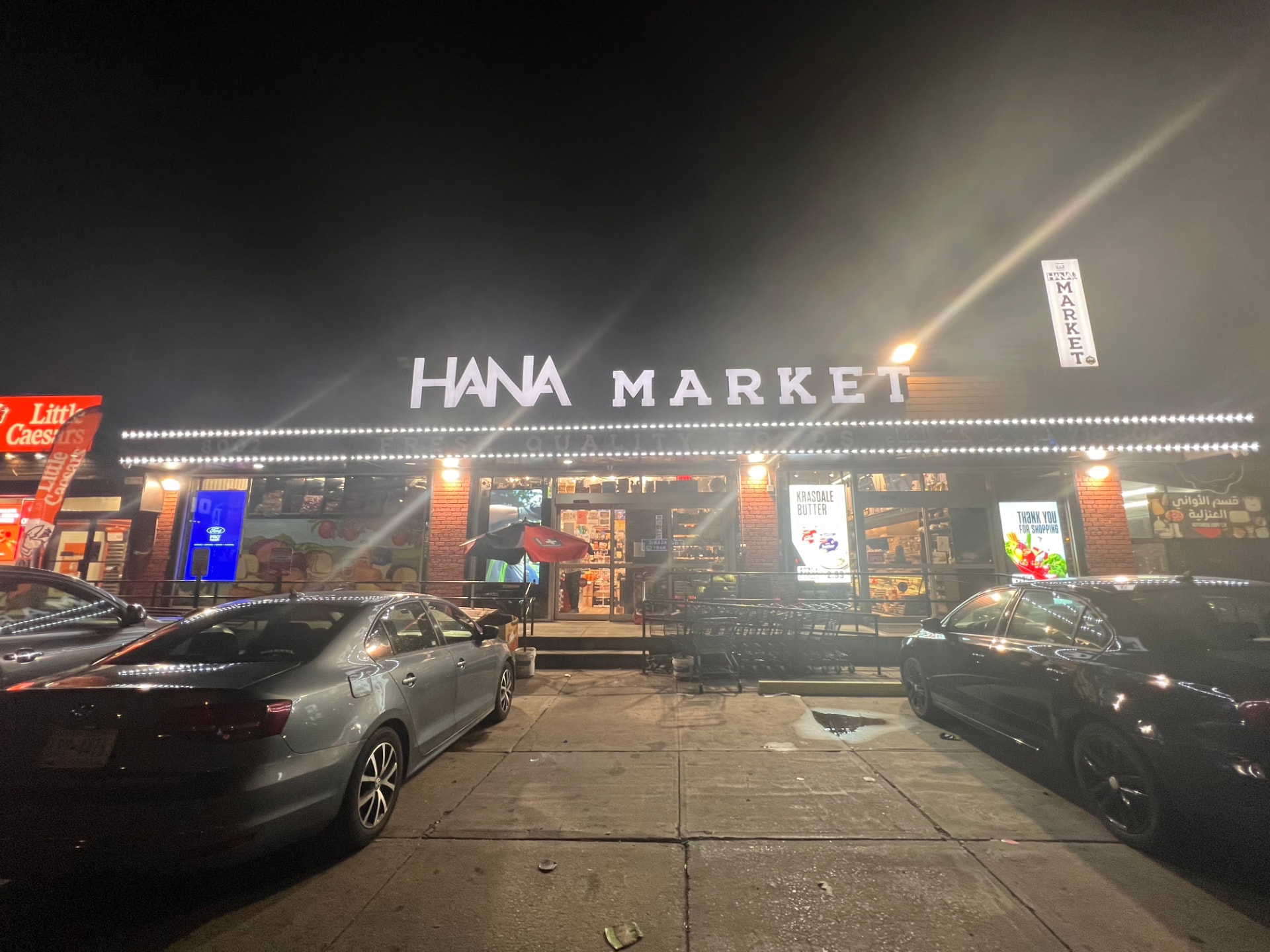 Hana Market storefront lit up at night